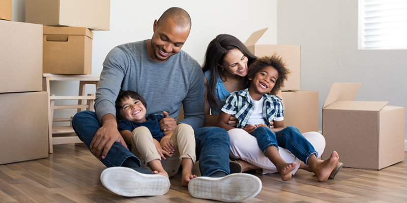 Family surrounded by moving boxes in new home